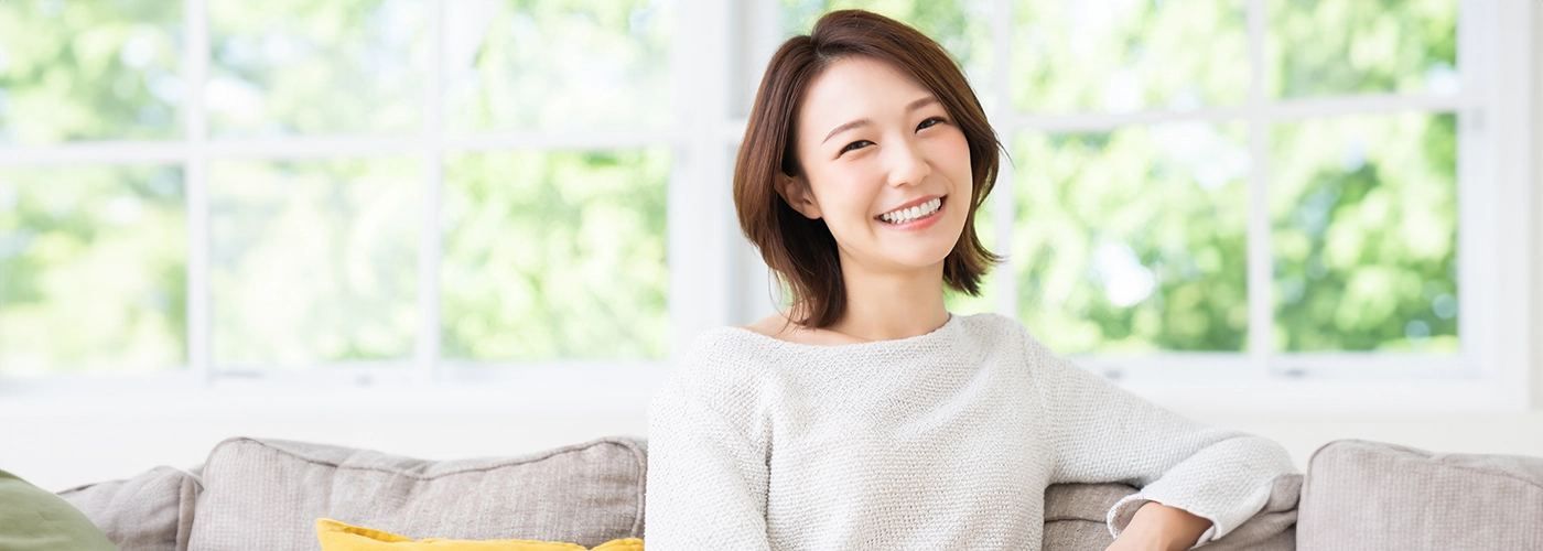 Woman smiling indoors relieved from period cramps